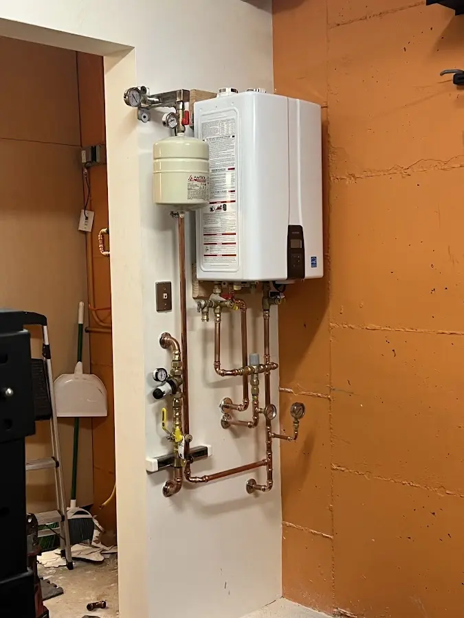 Plumbing technician inspecting water heater connections in Dyer